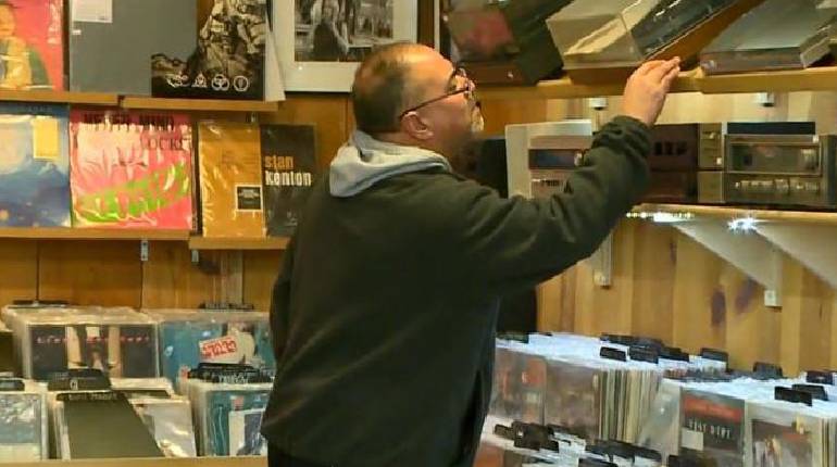 Image that shows a shopkeeper search for a book in his bookcemter