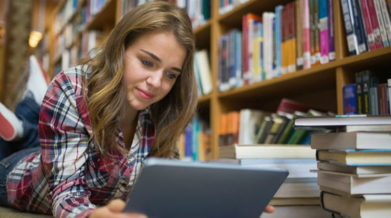 Image of A Teen girl reading digital book in Library