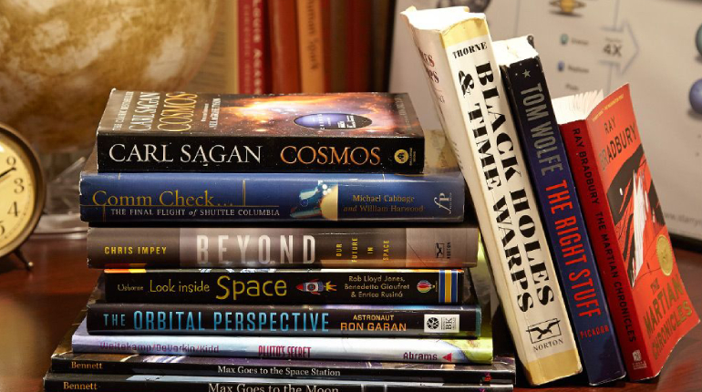 A Pile Of Books About Space Placed On The Table.