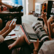 An image of a lady reading an article with a cup of coffee in other hand