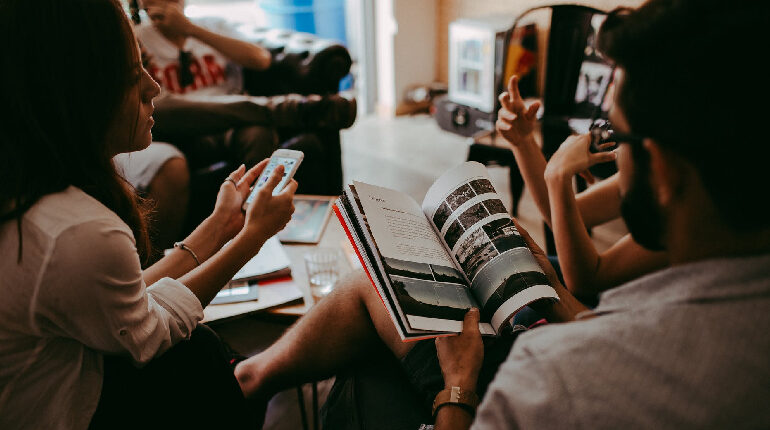 An image of a lady reading an article with a cup of coffee in other hand